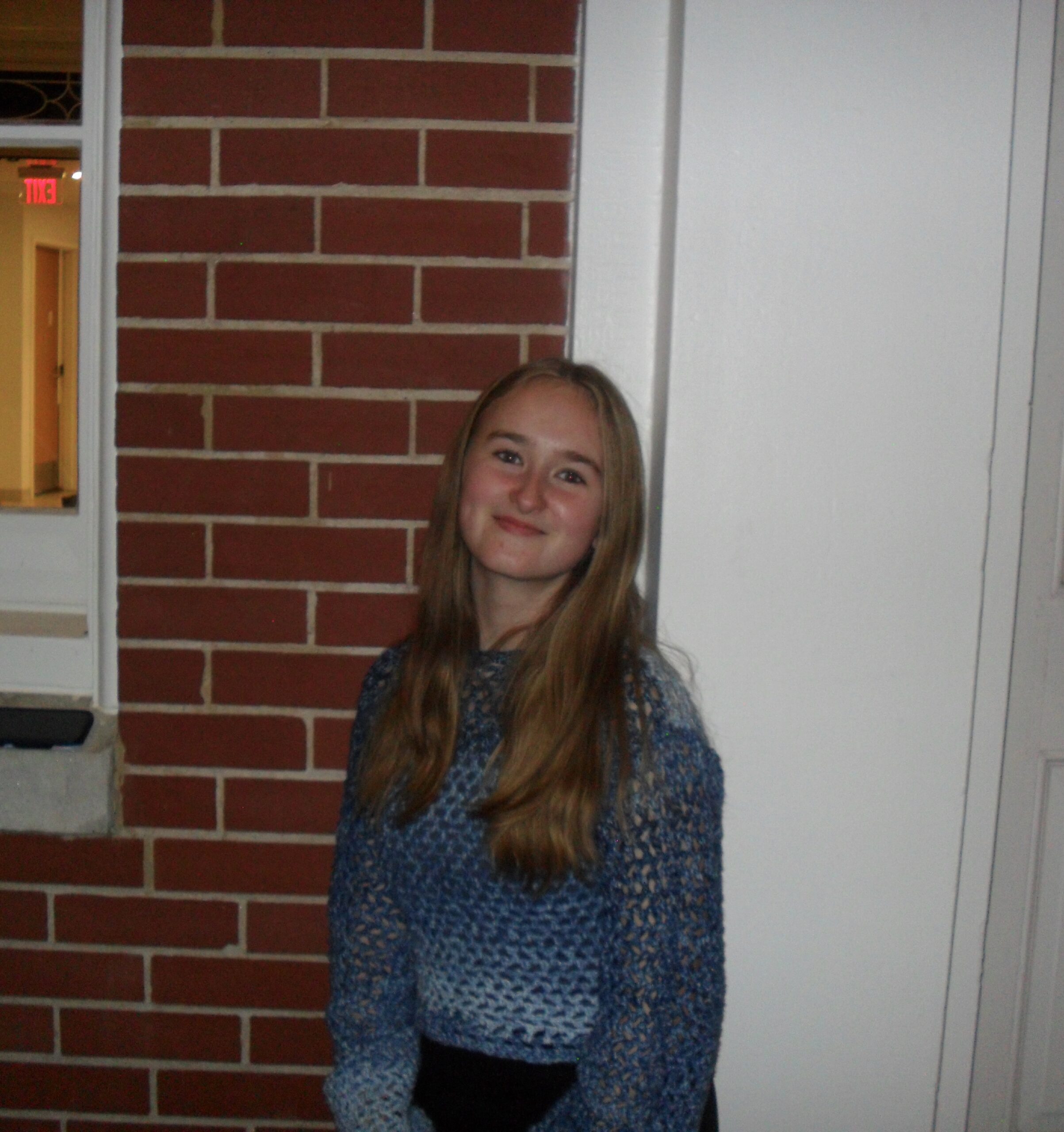 Erin McCarthy standing against brick wall.