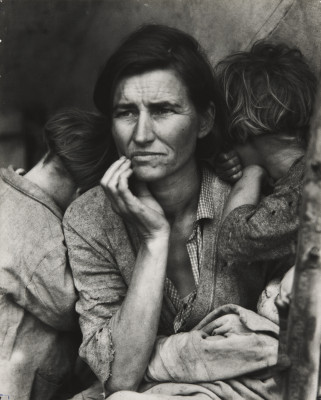 Image is black and white and shows a woman sitting with her hand to her face with a child in her arms and a child leaning on her shoulder