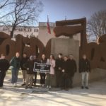 Students and Faculty holding UMW Banner in front of Solidarity Monument in Poland