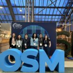 Professor and four students pose with the large letters OSM.