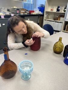 Student working on a glass vase in the archeology lab