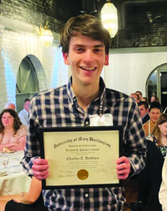 Charlie Barabaro holds award certificate at the Geography banquet