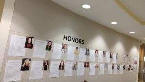 A wall with the word Honors and images of students and papers underneath.