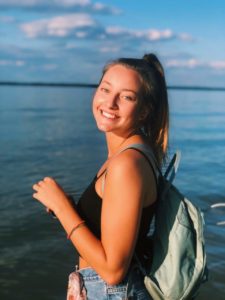 Image of Chloe Datner in front of blue water, smiling.