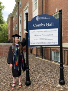 Mary Cheney stands by and points to Combs Hall directory sign.