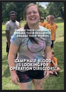 A person outdoors wearing t-shirt and shorts grins in front of younger people standing in the background. On screen text reads: Engage their creativity. Engage their resilience. Engage their stories. Camp Half-blood is looking for operation directors! 