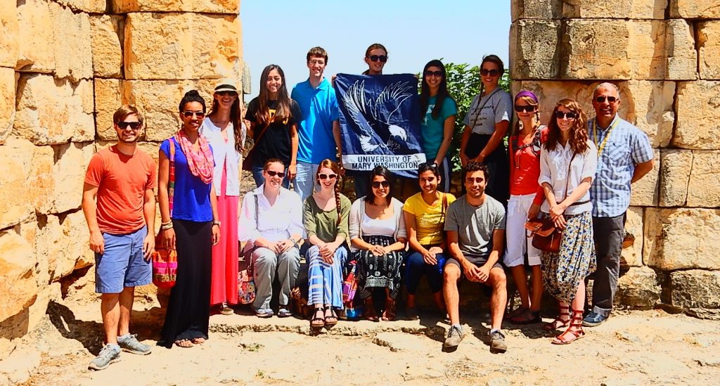 Students pose with UMW banner on study abroad trip to Morocco with Dr. Rouhani.