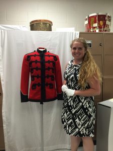 Courtney standing next to the original Special Full Dress Coat worn by the Marine Band beginning in 1904