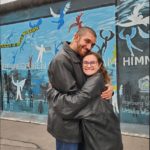 Gabriel Matteson hugging another student in front of The East Side Gallery in Berlin.