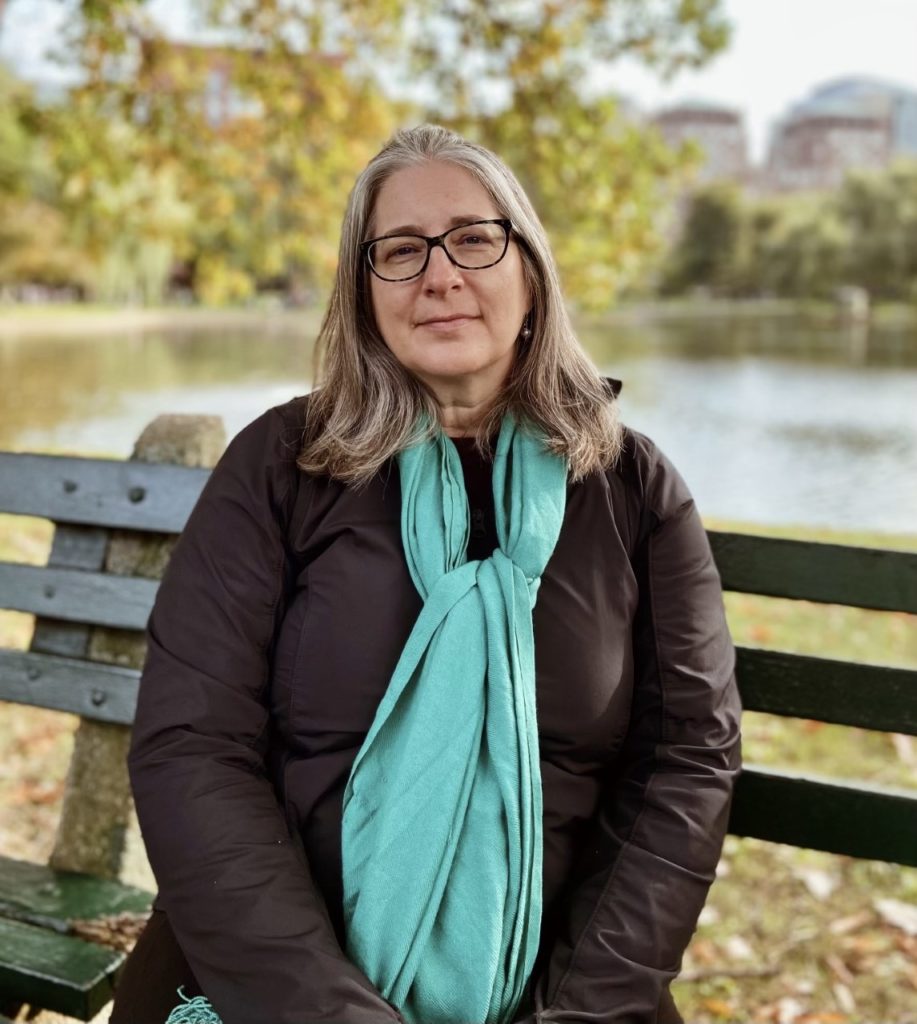 Professor Rosalyn Cooperman surrounded by nature backdrop outside.