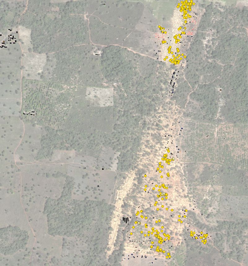 Satellite image in gray tones with yellow dots marking the location of mines